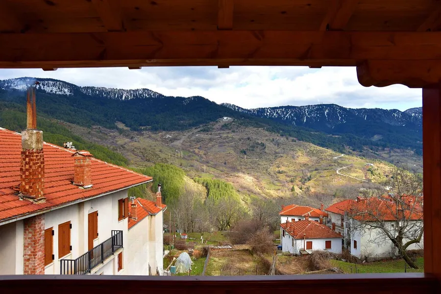 Θέα από το μπαλκόνι στις στέγες του Μετσόβου και στα βουνά