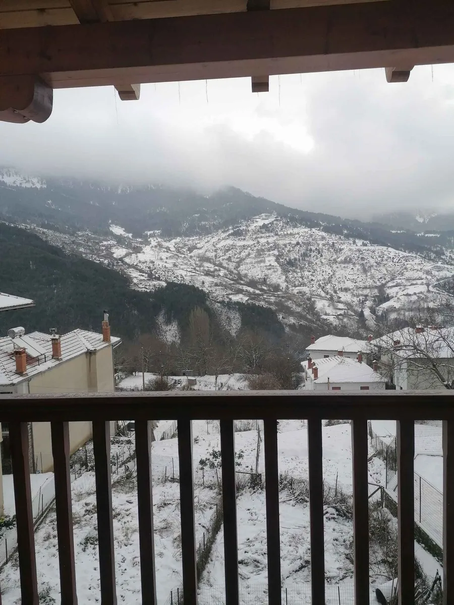 Χιονισμένα βουνά και στέγες από το μπαλκόνι